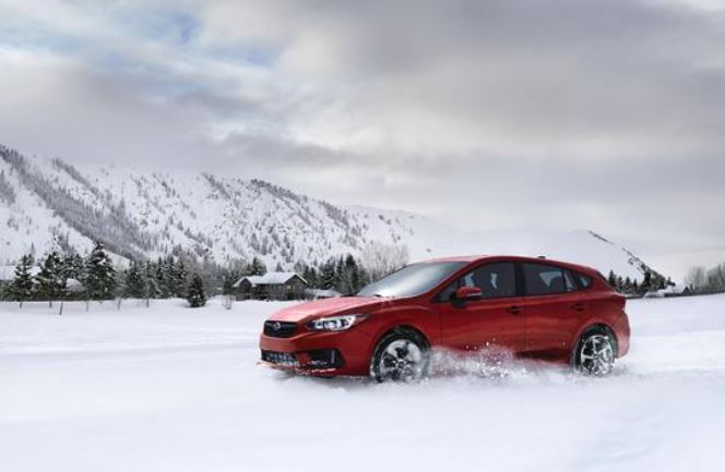 Parents magazine has endorsed the Subaru Impreza for teen drivers. A red five-door hatchback model is shown here in a heavily-snowed winter scene. 